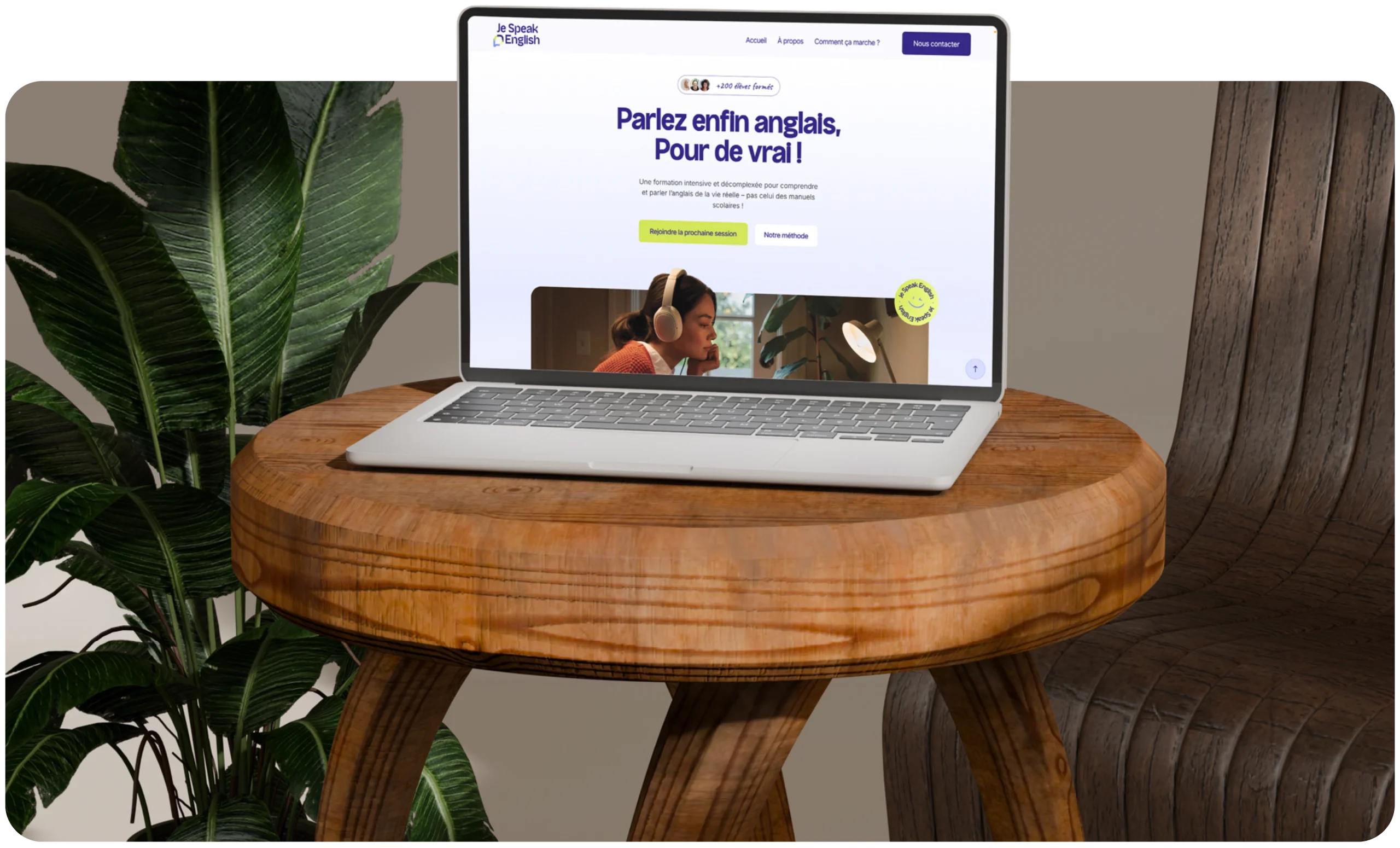 Ordinateur posé sur une chaise en bois affichant la page d’accueil du site Je Speak English